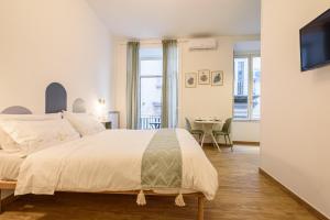 1 dormitorio con 1 cama grande y 1 mesa en EcoSuite Spaccanapoli, en Nápoles