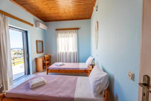 a room with two beds and a window at Ocean Breeze Apartment in Kipseli