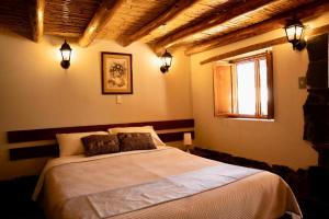 a bedroom with a bed and a window and lights at Lodge El Portal de Qopuy in Coporaque