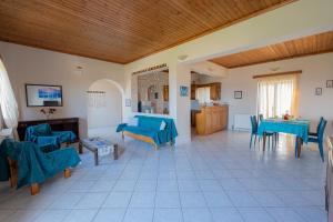 sala de estar con sillas azules y mesa en Ocean Breeze Apartment, en Kypseli