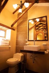 y baño con lavabo, aseo y espejo. en Lodge El Portal de Qopuy, en Coporaque