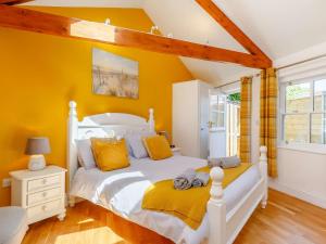 um quarto com uma cama branca e paredes amarelas em 1 Bed in Marazion 86149 em Saint Hilary