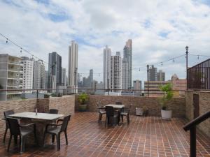 un patio con mesas y sillas y un perfil urbano en Hotel Costa Inn en Panamá