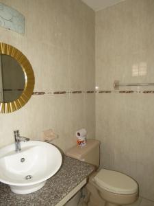 a bathroom with a sink and a toilet and a mirror at Hotel Costa Inn in Panama City