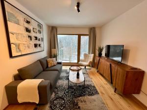 a living room with a couch and a tv at Golden Ridge Apartments in Špindlerův Mlýn