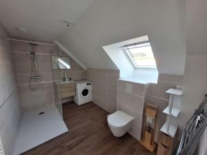 Un baño con inodoro, lavabo y ventana. en Appartement Campénéac, en Campénéac