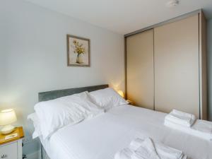 um quarto com uma cama branca e uma grande cabeceira de cama. em 1 Bed in Brockenhurst 78730 em Brockenhurst