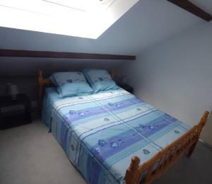 Schlafzimmer mit einem Bett mit blauer Decke in der Unterkunft T2 DUPLEX - VUE MER - 150 m DE LA PLAGE in Ploemeur