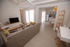 a living room with a couch and a television at Playas Art Hotel in Pinamar