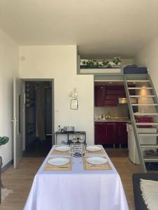 a kitchen with a table with a white table cloth at DINAPARK in Dinard