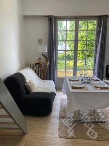 a living room with a table and a couch at DINAPARK in Dinard