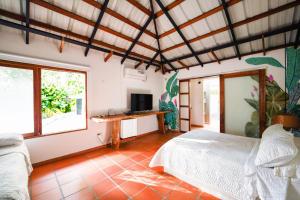 a bedroom with a bed and a desk with a television at Casa Cumbres Ecolodge in Yopal