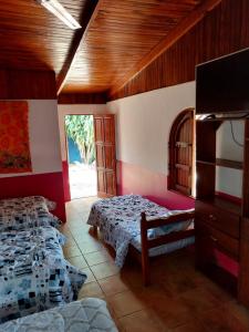 een slaapkamer met 2 bedden en een tv. bij Las cabinas del sueño in Nicoya