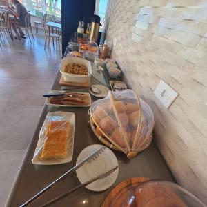 a buffet with bread and other food on a table at Pousada Fenícia in Japaratinga