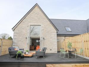 a patio with chairs and a table in front of a building at Ysgol Fach Little School in Brynteg