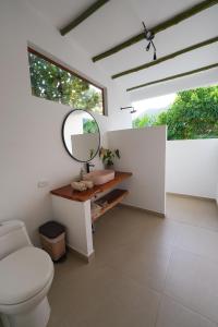 a bathroom with a toilet and a mirror at Casa Cumbres Ecolodge in Yopal +13 photos