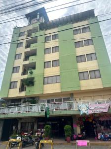 a large green building with a balcony in front of it at Hotel Sulicam in Neiva