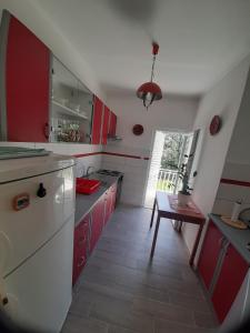 a kitchen with red cabinets and a table in it at Franceska in Korčula