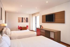 a hotel room with two beds and a flat screen tv at 84 DC Bogotá in Bogotá