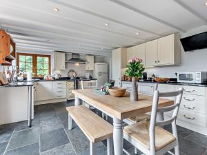 a kitchen with a wooden table and chairs at 5 Bed in Bransgore 91304 in Bransgore