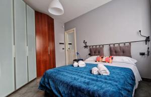 1 dormitorio con 1 cama grande y toallas. en MYHOUSE INN FERMATA PARADISO - Affitti Brevi Italia, en Collegno