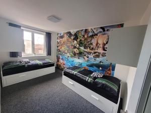 - une chambre avec 2 lits et une fresque murale dans l'établissement Dům Pálava, à Perná