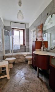 baño con 2 lavabos, bañera y 2 aseos en MYHOUSE INN FERMATA PARADISO - Affitti Brevi Italia, en Collegno