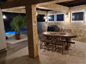 jadalnia ze stołem i krzesłami oraz kamienną ścianą w obiekcie Bellavista Medulin Sea View w Medulinie