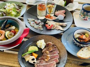 una mesa de madera con platos de comida. en Umi no Gohanya Noramare - Vacation STAY 18208v, en Masuda