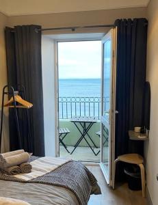 a bedroom with a view of the ocean from a balcony at BlueSeaView Apartment with fabulous sea views in Newcastle