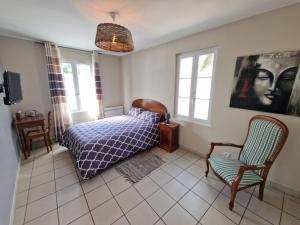 a bedroom with a bed and a chair at Les Chambres de Beaumont in Beaumont-Village