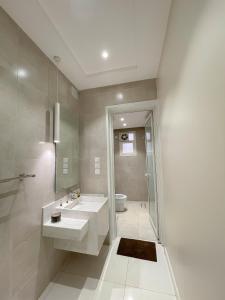 ein Bad mit 2 Waschbecken und einer Dusche in der Unterkunft نزل الراشد الفاخرة luxury in Abha