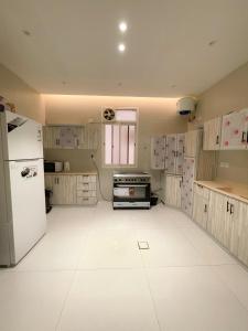 Il comprend une cuisine dotée d'un sol blanc et d'un réfrigérateur. dans l'établissement نزل الراشد الفاخرة luxury, à Abha