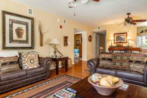 a living room with two leather couches and a table at Luxury Whispering Pines Condo with Pools in Pigeon Forge