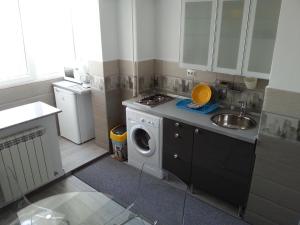 a kitchen with a washing machine and a sink at Universitate Residence in Bucharest
