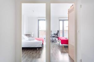 1 dormitorio con 1 cama y 1 habitación con espejo en A proximité de Paris, en Saint-Denis