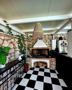a living room with a fireplace and a checkered floor at Luxury Villa Athina in Nikiana