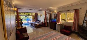 a room with a bed and a living room with a television at Top Ourika in Aghbalou