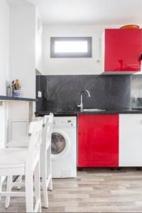 cocina con lavadora y armarios rojos en A proximité de Paris, en Saint-Denis