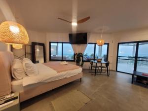 1 dormitorio con 1 cama y sala de estar con ventanas en ציפור הכנרת - Sea of Galilee bird, en Had Nes