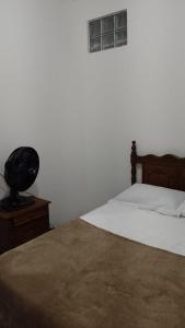 1 dormitorio con 1 cama con cabecero de madera y mesa en Casa de Guinho, en São Félix