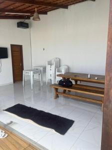 sala de estar con mesa, sillas y alfombra en Recanto Boulevard, en Tibau do Sul