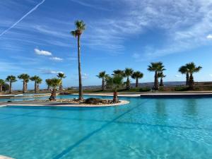 a swimming pool with palm trees in the background at Fort Chambray, Blissful Escape in Għajnsielem