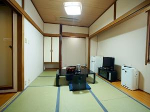 ein Wohnzimmer mit einem Tisch und einem TV. in der Unterkunft HOTEL MARINEPIA - Vacation STAY 92243v in Shinkamigoto
