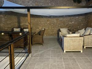 a patio with wicker chairs and a white canopy at Las Terrazas del Castillo in Almansa