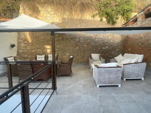 um pátio com uma mesa, cadeiras e um guarda-sol em Las Terrazas del Castillo em Almansa