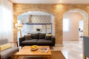 a living room with a couch and a table at AtGr Luminoso Ático con Terraza, Calle Antonia Diaz in Seville