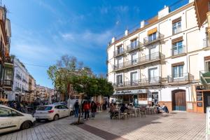 een drukke straat met gebouwen en mensen die op de stoep lopen bij AtGr Luminoso Ático con Terraza, Calle Antonia Diaz in Sevilla