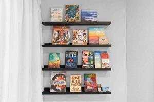 une étagère remplie de livres sur un mur dans l'établissement Pensacola Whimsy Hideaway: Quirky Apartment Near NAS, à Pensacola