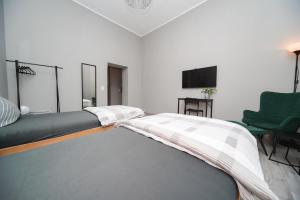 ein weißes Zimmer mit einem Bett und einem grünen Stuhl in der Unterkunft Apartment Central 85B 40qm Wi-Fi free in Dortmund